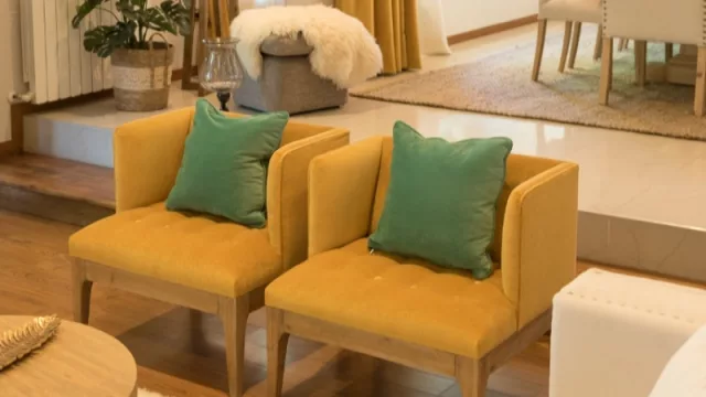 Poltronas Ziggy tapizadas en veluti yellow, almohadones en pana de algodón color menta, cesto Batu con planta monstera.